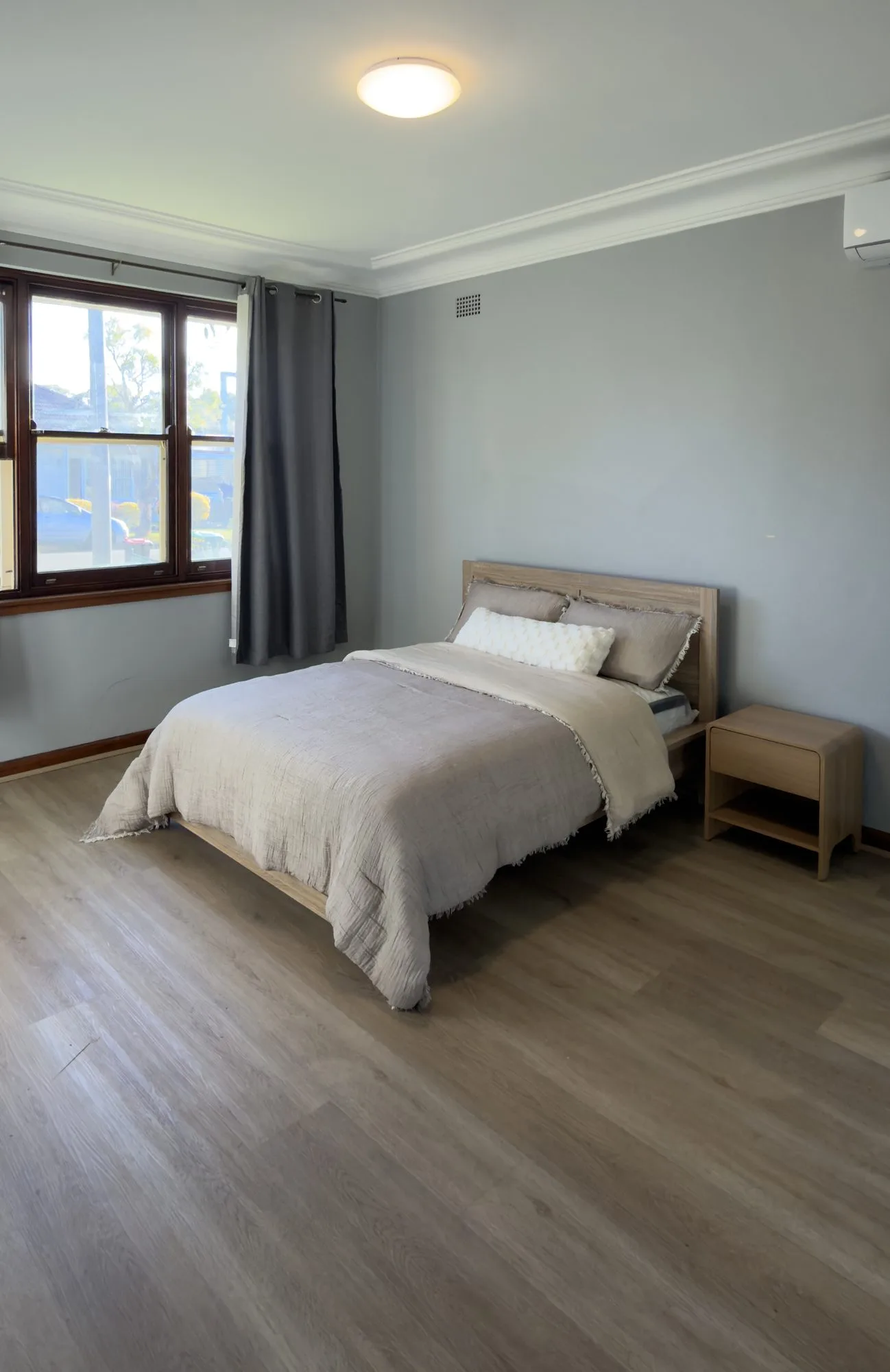 A private bedroom with a double bed, bedside table and air conditioning