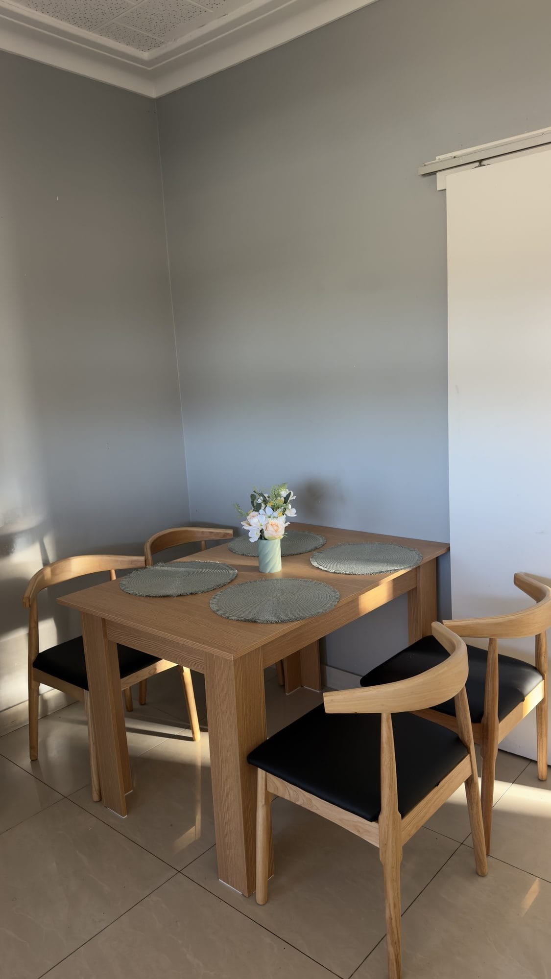 Dining area with a timber table and four chairs where housemates share meals