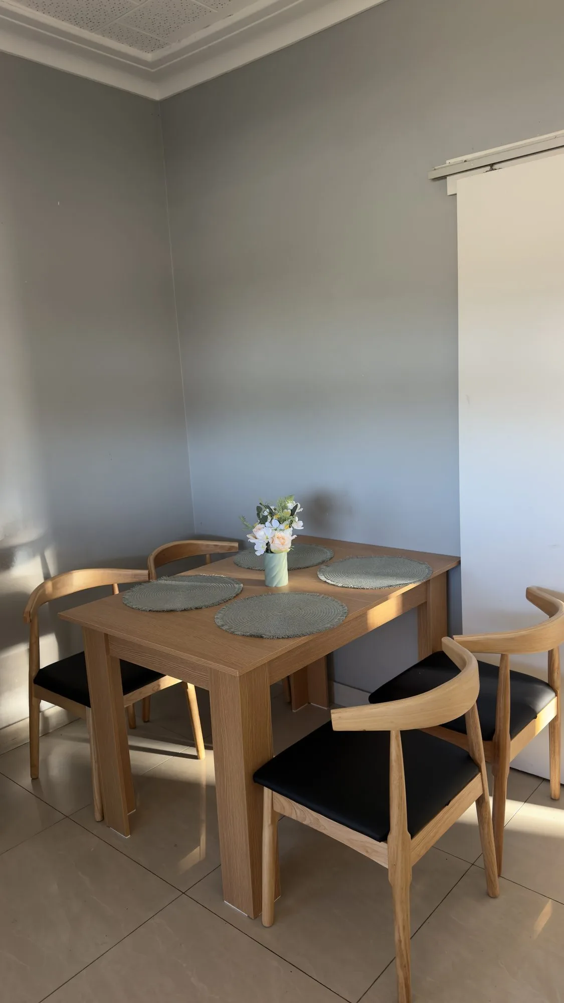 Dining area with a timber table and four chairs where housemates share meals